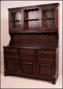 A 20th century Jacobean revival oak dresser having plate rack over cupboard with short drawers and