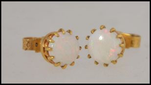 A pair of 9ct gold stud earrings both mounted with an opal stone,
