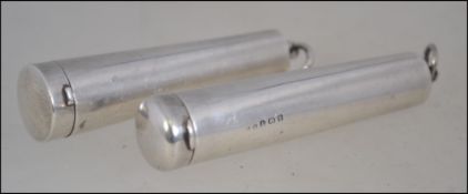A pair of silver hallmarked cheroot holders, both having hinged cap ends,