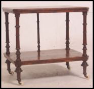 A Victorian walnut side table raised on turned column supports with white ceramic castors.