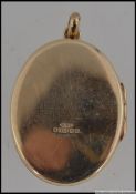 A hallmarked 9ct gold locket with flower decoration to front set with a cluster of garnets.