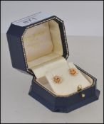 A pair of 9ct gold rose stud earrings each stud stamped 375 to the stud posts