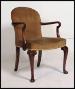A 20th century Georgian revival open armchair raised on cabriole legs with ball and claw feet