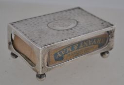 A silver hallmarked match box holder, having a central cartouche monogram, raised on bun feet,