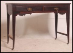 An Edwardian mahogany writing table being raised on turned legs with castors having twin frieze