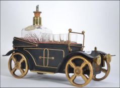 A vintage novelty musical decanter and glass set in the form of a motor car L35cm