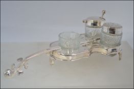 An unusual silver plated condiments set in the form of a cello consisting of glass condiments with