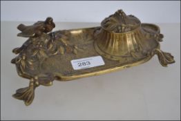 A late 19th century cast brass desk tidy adorned with a pair of perching doves having a central