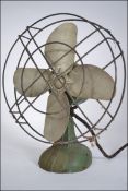 A good early to mid 20th century vintage industrial desk fan having a tilting fan raised on a green