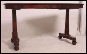 A Regency 19th century rosewood library table - writing desk raised on turned column supports