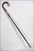 A 20th century walking stick having a 18ct gold plated metal collar and brass feral H91cm