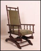 A Victorian Boston rocker armchair having velour upholstered seat and back rest with bobbin turned