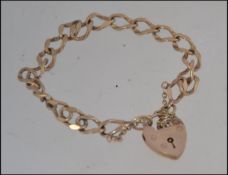 A 9ct hallmarked 375 gold curb bracelet with a 9ct gold hallmarked heart locket,