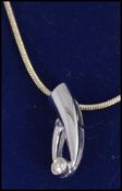 A white gold diamond drop pendant with single stone