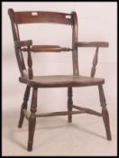 A Victorian beech and elm Oxford Windsor back back armchair having saddle seat and raised on turned