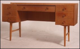 A retro 1970's danish influence desk having a central long drawer with two banks of three either