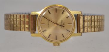 A 20th century yellow metal Omega ladies dress watch set to an expanding bracelet.