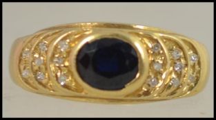 A yellow metal tests 18ct gold but unmarked ring with large oval sapphire and diamonds to the
