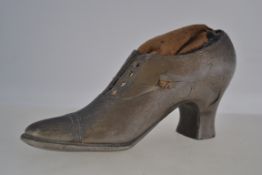 A 19th century Georgian large pewter pin cushion in the form of a gentlemans shoe with fabric upper