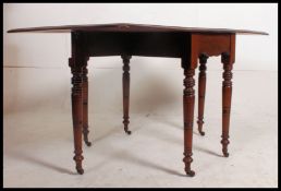 A Victorian 19th century solid mahogany drop leaf pembroke dining table being raised on turned legs,