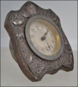 A silver hallmarked Art Nouveau desk clock having floral decoration in repose,