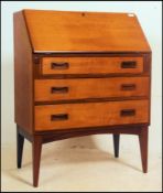 A 1970's retro teak wood Danish inspired full front bureau having a fully appointed interior above