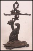 A Victorian cast iron stick stand modelled as a seated dog beneath tangled branches acting as two