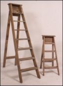 A vintage wooden eight rung step ladder along with a near matching smaller four rung wooden step