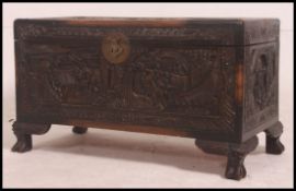 A Chinese camphor wood coffer profusely carved with characters,