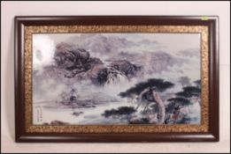 A very large 20th century Chinese framed ceramic tile transfer printed with mountain scenes having
