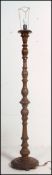 A 1950's carved mahogany standard lamp with terraced base and unusual carved upright
