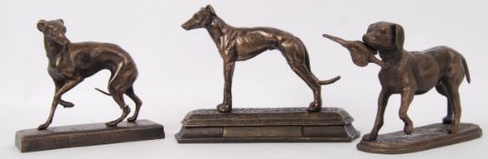A collection of 3x bronze effect metal statues of greyhounds.