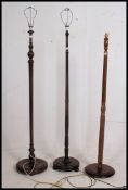 A collection of 3 standard lamps to include mahogany and beech examples having turned columns and