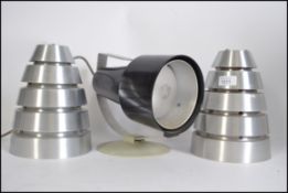 A pair of 1970's retro beehive conical polished light fixtures along with a polished metal ceiling