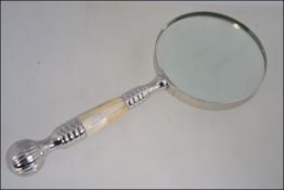 A hand held magnifying glass with a mother of pearl handle L25cm