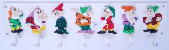 A Snow White & The Seven Dwarfs style hand painted metal coat / cup rack.