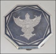 A 20th century silver Siam ladies compact with inset deity decorative top. Weight 59.