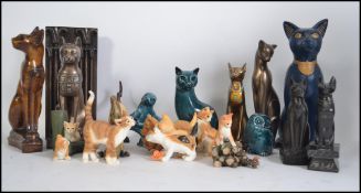 A large collection of cat ornaments of various differing styles and poses to include china,