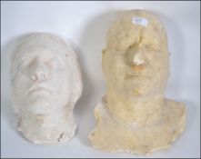 Two plaster cast death masks the first of middle aged man and the second belonging to a female