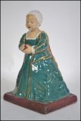 A Maude Bateman early 20th century pottery figurine of a renaissance child in bed cap.