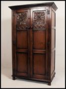 An excellent quality Ipswich oak Jacobean revival wardrobe having linen fold carved doors with