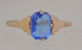 A 9ct gold ladies dress ring with inset square cut blue sapphire garnet stone. Weight 1.8g / Size P.