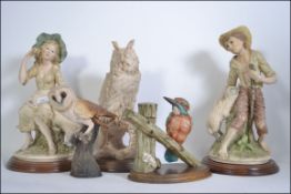 A pair of Naples / Capodimonte ceramic figures of a seated boy and girl along with ceramic figures