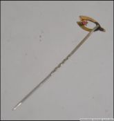 An early 20th century tie pin set with a 9ct gold wishbone motif. Tests 9ct. Measures 5cms.