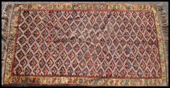 A Sanjabi kurd rug of geometric form with colourful ground and tassled ends dating to the 20th