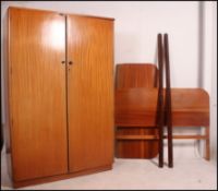 A 1950's walnut bedroom suite comprising a tallboy cabinet, double wardrobe,