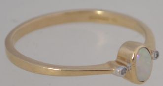 A 9ct gold and opal ladies dress ring of fine form having oval opal flanked by 2 x 1pnt diamonds