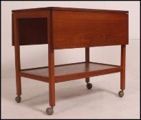 A 1970's retro teak drop leaf Danish influence butlers - hosting trolley being raised on castors