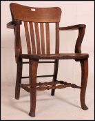 A good 1920's solid oak Industrial office swivel chair raised on a quadruped base with saddle seat