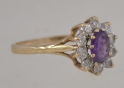 A 9ct gold and amethyst ladies dress ring, the central stone being oval cut surrounded by cz stones.